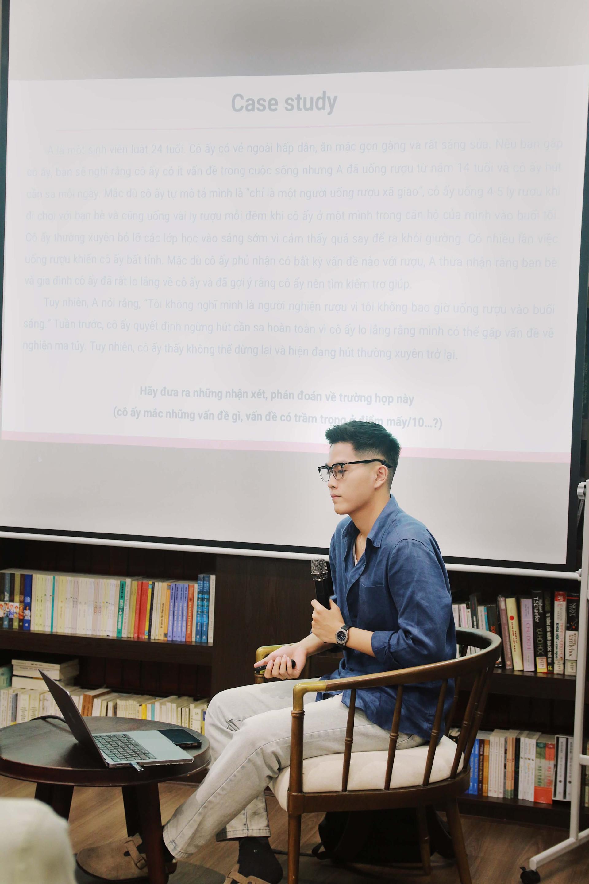 Người trình bày cầm micro trước màn chiếu ghi “Case study”.